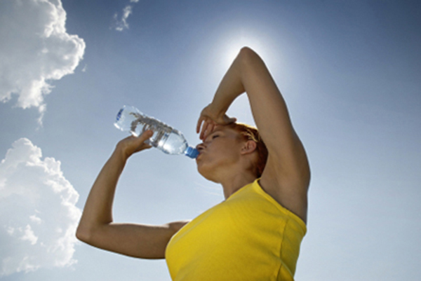 por que hace mas calor en verano mujer bebiendo agua